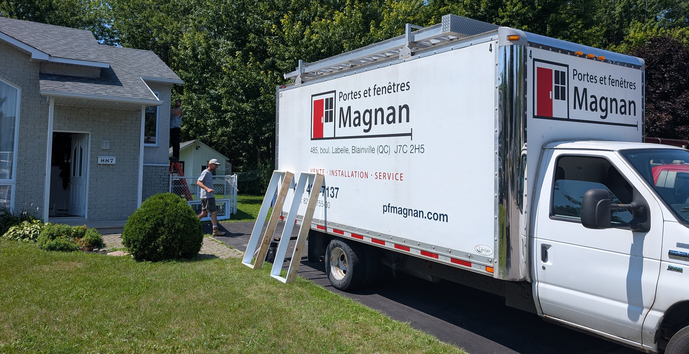 Camion Portes et Fenêtres Magnan stationné devant une résidence pendant une installation de fenêtres